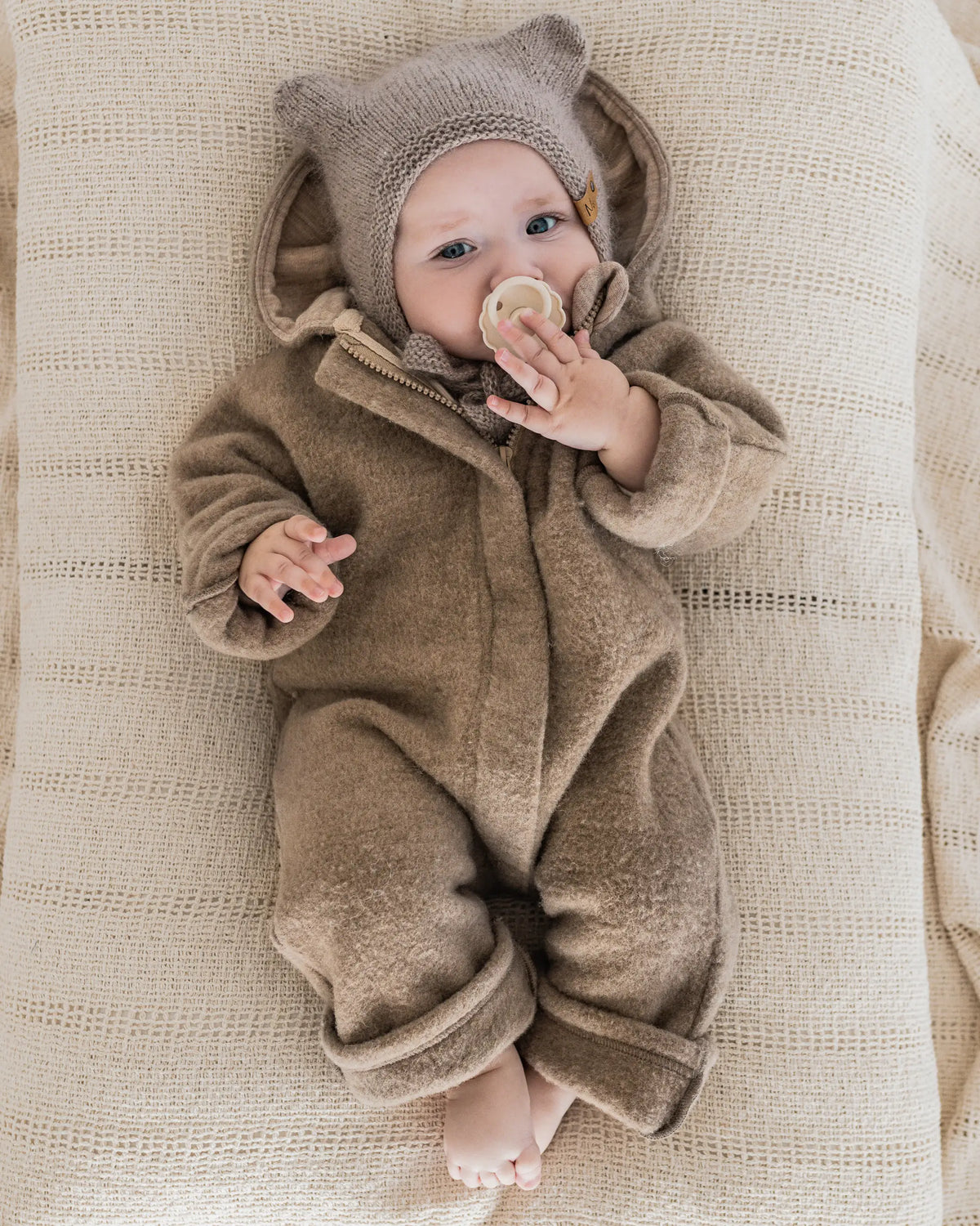 Nachhaltiger Baby Wollfleece Overall aus  Merino Wollfleece mit Kapuze, Umschlägen und verdecktem Reißverschluss