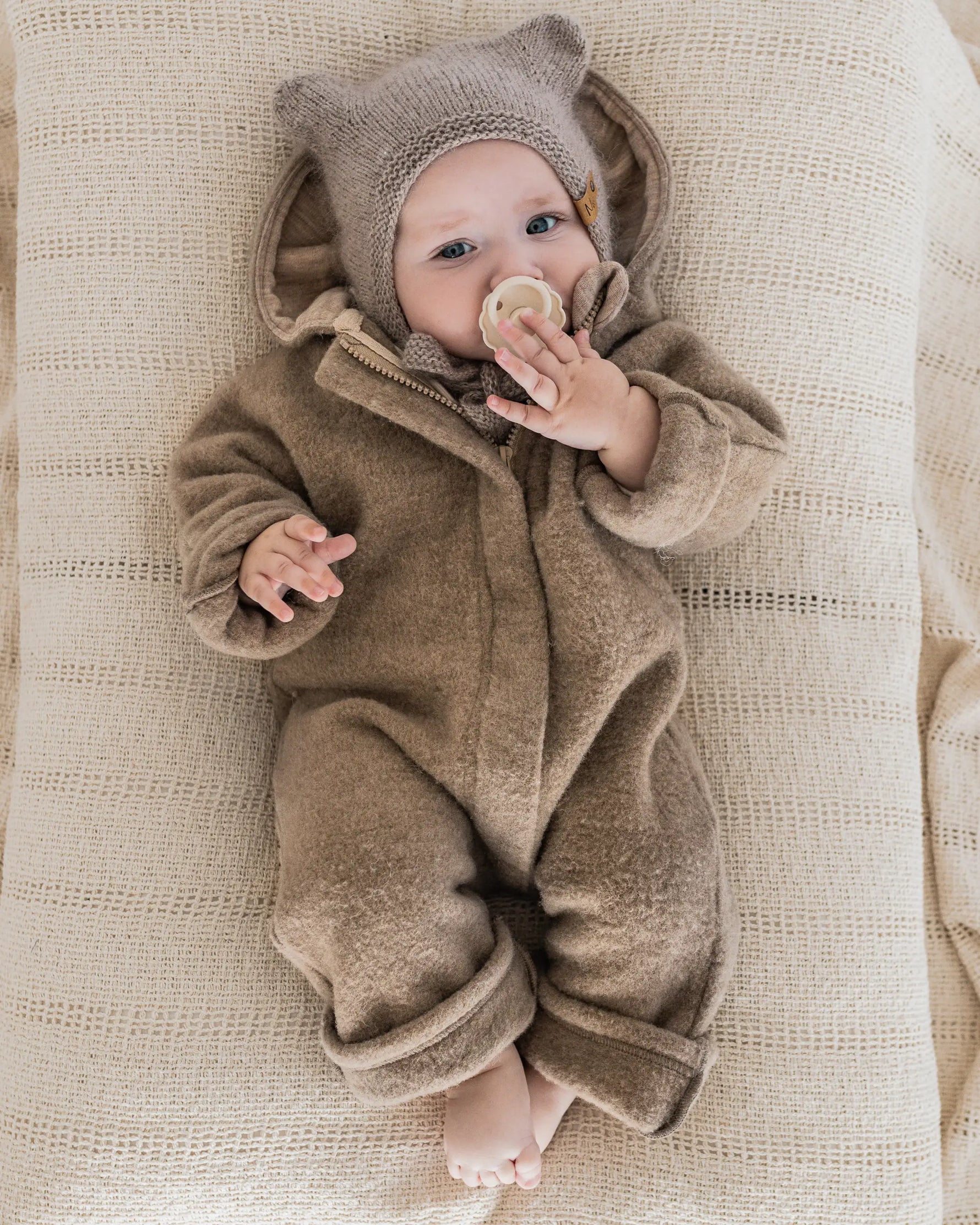Nachhaltiger Baby Wollfleece Overall aus  Merino Wollfleece mit Kapuze, Umschlägen und verdecktem Reißverschluss