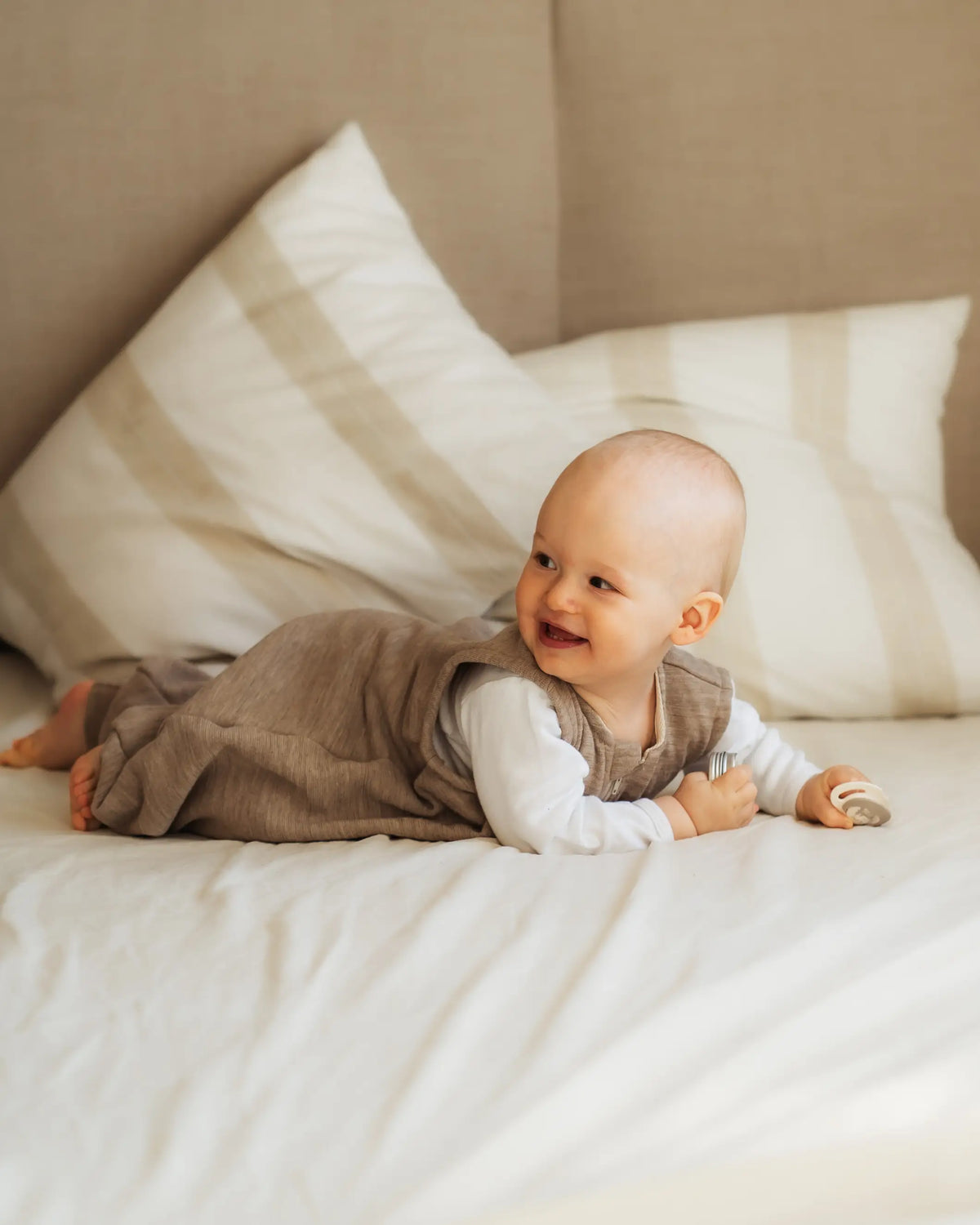 glückliches Baby in Merino Wollfrottee Schlafsack mit Beinen für Kleinkinder, hochwertige und nachhaltige wichtelkidz qualität