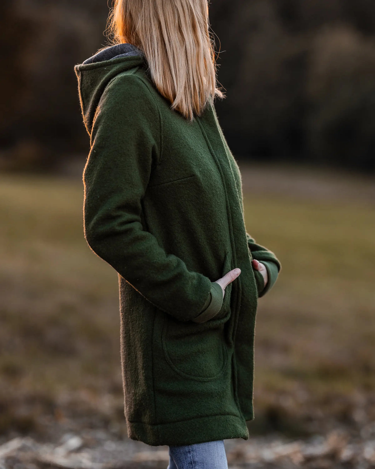 Frau trägt warmen Walkmantel aus Schurwolle mit Kapuze, ideal für Spaziergänge im Herbst und Winter, atmungsaktive nachhaltige Damenmode