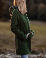 Frau trägt warmen Walkmantel aus Schurwolle mit Kapuze, ideal für Spaziergänge im Herbst und Winter, atmungsaktive nachhaltige Damenmode