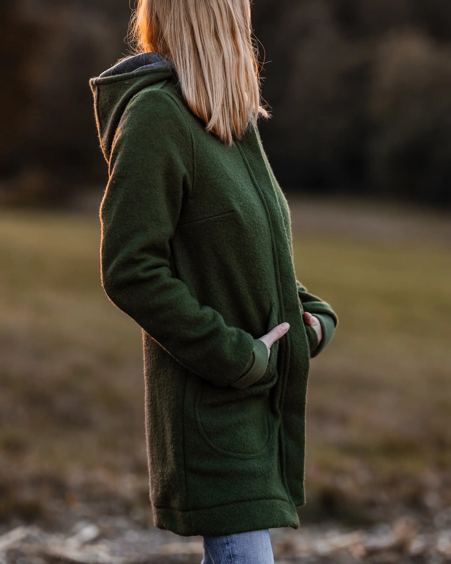 Frau trägt warmen Walkmantel aus Schurwolle mit Kapuze, ideal für Spaziergänge im Herbst und Winter, atmungsaktive nachhaltige Damenmode