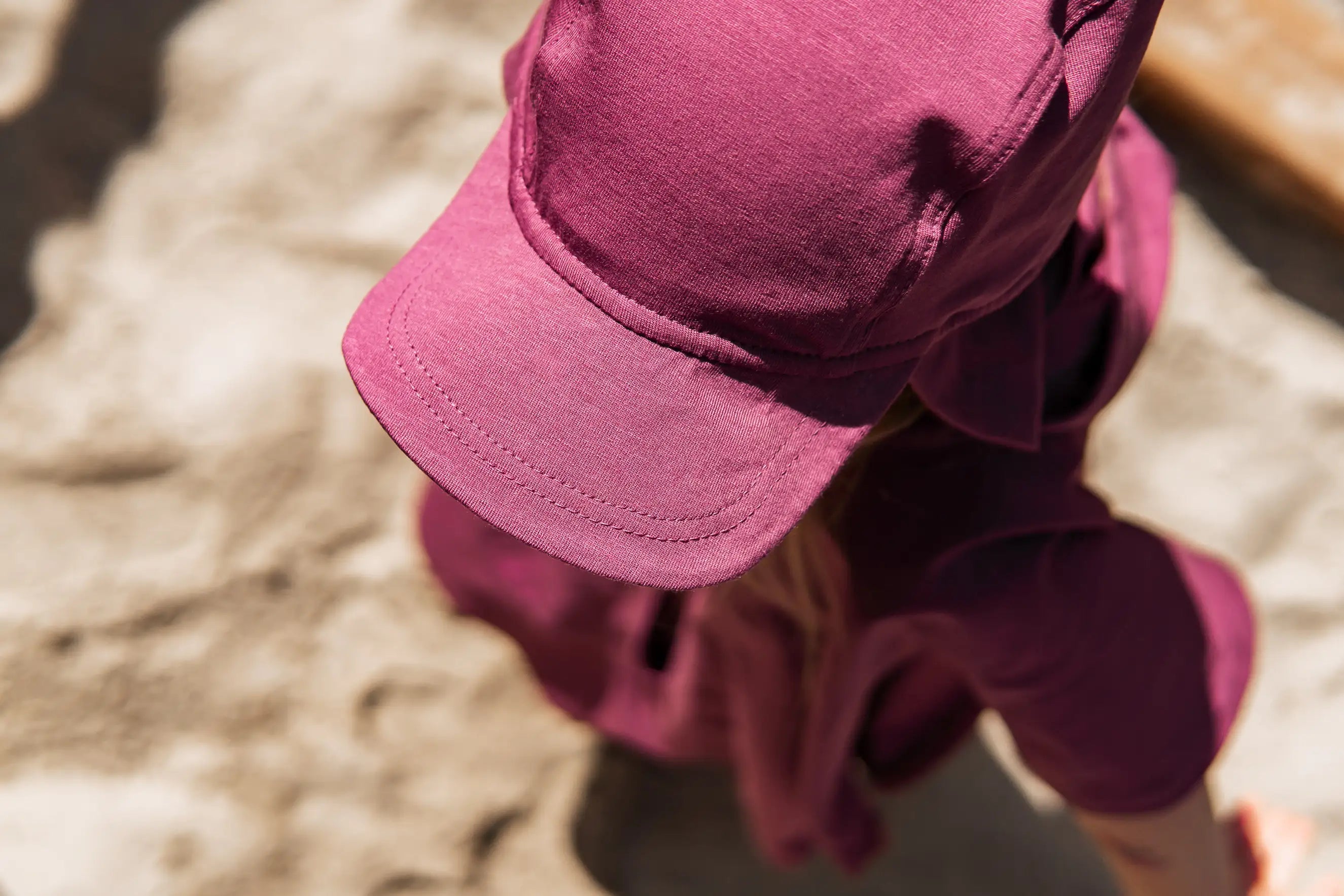 Atmungsaktiver UV-Poncho im Set mit Sonnenhut für Kinder beim Spielen im Sandkasten und auf der Terrasse. Der natürliche Sonnenschutz entsteht durch die besondere Stoffmischung und dichte Webart.