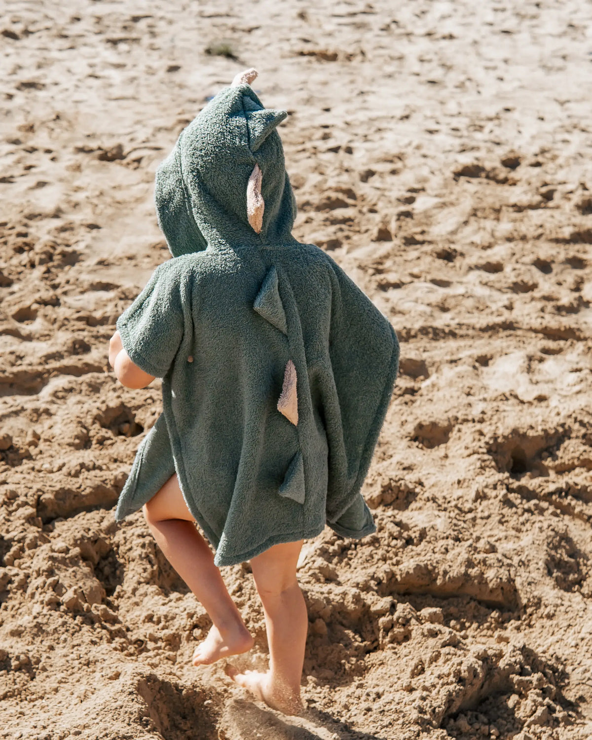 Kinder-Badeponcho aus Baumwoll-Frottee im Dino-Design mit Kapuze, Dinozacken und Bauchtasche – saugfähig, weich und ideal zum schnellen Abtrocknen nach Badewanne, Strand oder Schwimmbad.