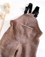 Detailaufnahme von Walklatzhose mit verstellbaren Trägern und Tasche, handgemachte Kinderkleidung aus Bio Materialien