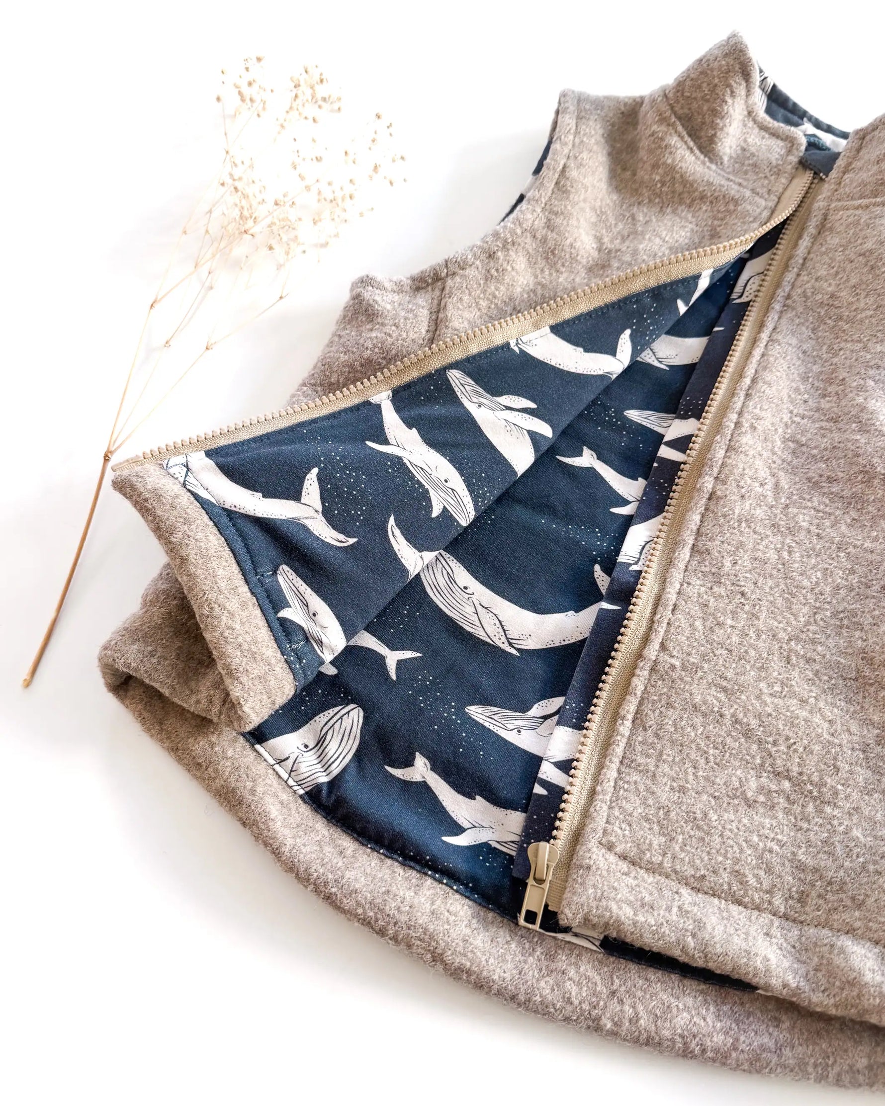 Detailaufnahme von gefütterter Walkweste mit Reißverschluss und Kapuze, handgemachte Baby und Kinderkleidung aus Wollwalk