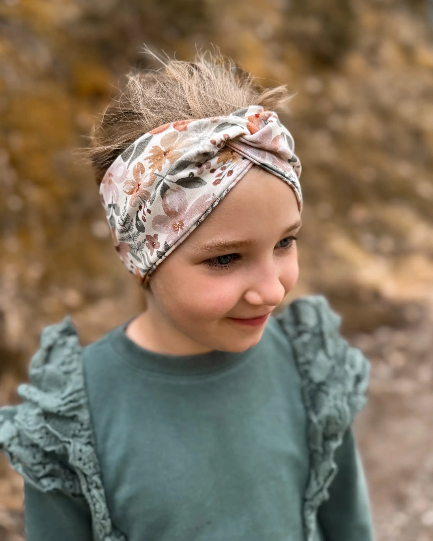 Mädchen in der Natur mit Stirnband mit Twist in tollen floralen Mustern. Perfekt für Frühling, Herbst und WInter