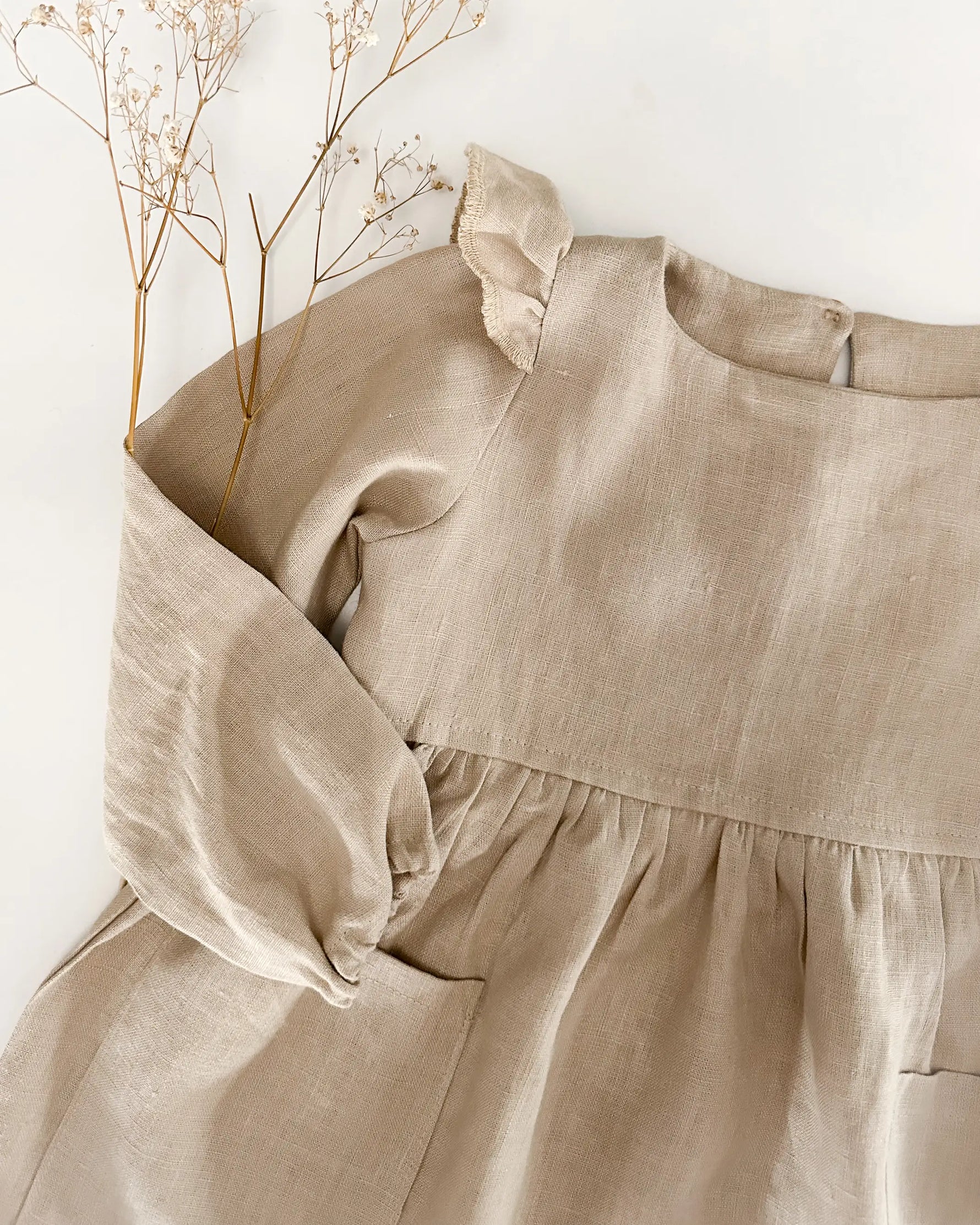 Wichtelkidz baby und Kinder Kleid aus 100% weichem Leinen und gepufften Flügelärmeln. Leinenkleid mit langen Ärmeln für Frühling, Sommer, Herbst und Winter. Nachhaltig, regional und fair produziert. Ein Kleid für Madchen, dass sich perfekt als Outfit für Taufe, Geburtstag, Hochzeit, Weihnachten und andere festliche Anlässe eignet.