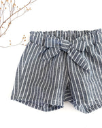 Paperbag Shorts fuer Mädchen und babys aus hochwertigem und weichem 100% gewaschenem Leinen. Kurze Hose für Mädchen mit süßer Schleife zum Binden. Nachhaltig, Fair, atmungsaktiv, Antibakteriell und  bequem. Perfekt fuer heiße Sommertage.