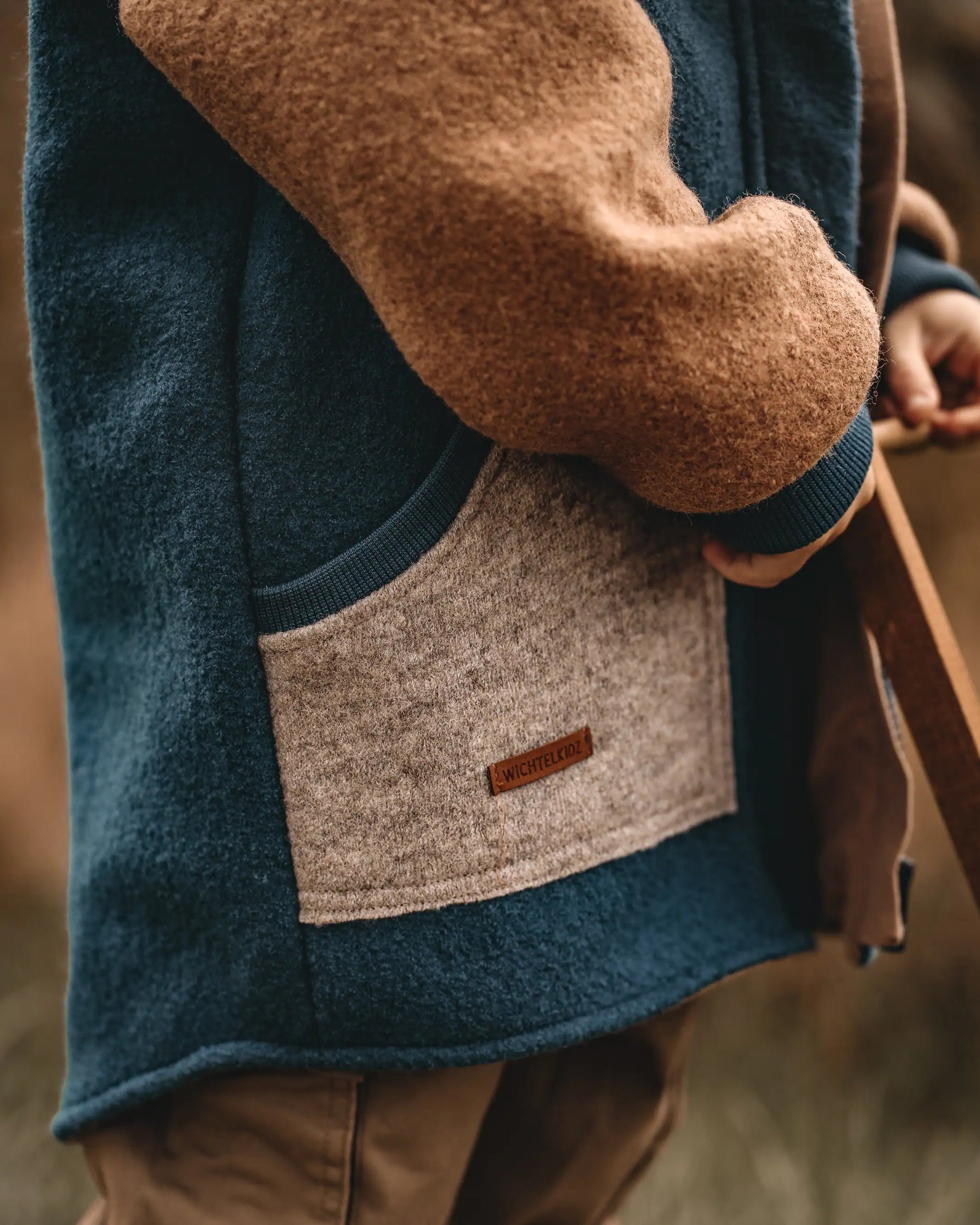 Detailaufnahme blaue Colorblockjacke aus Wollwalk für Kinder mit Taschen und Reißverschluss