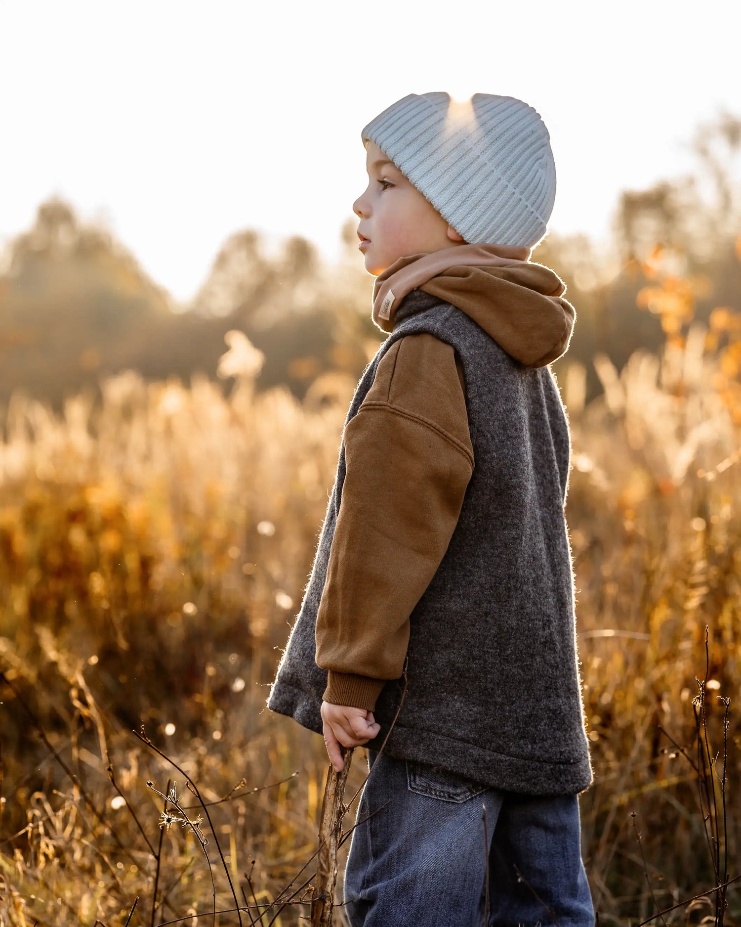 Kind trägt Walkweste aus Wollwalk beim Spielen im Freien, nachhaltige Kinderkleidung aus 100% Schurwolle für Frühling und Herbst
