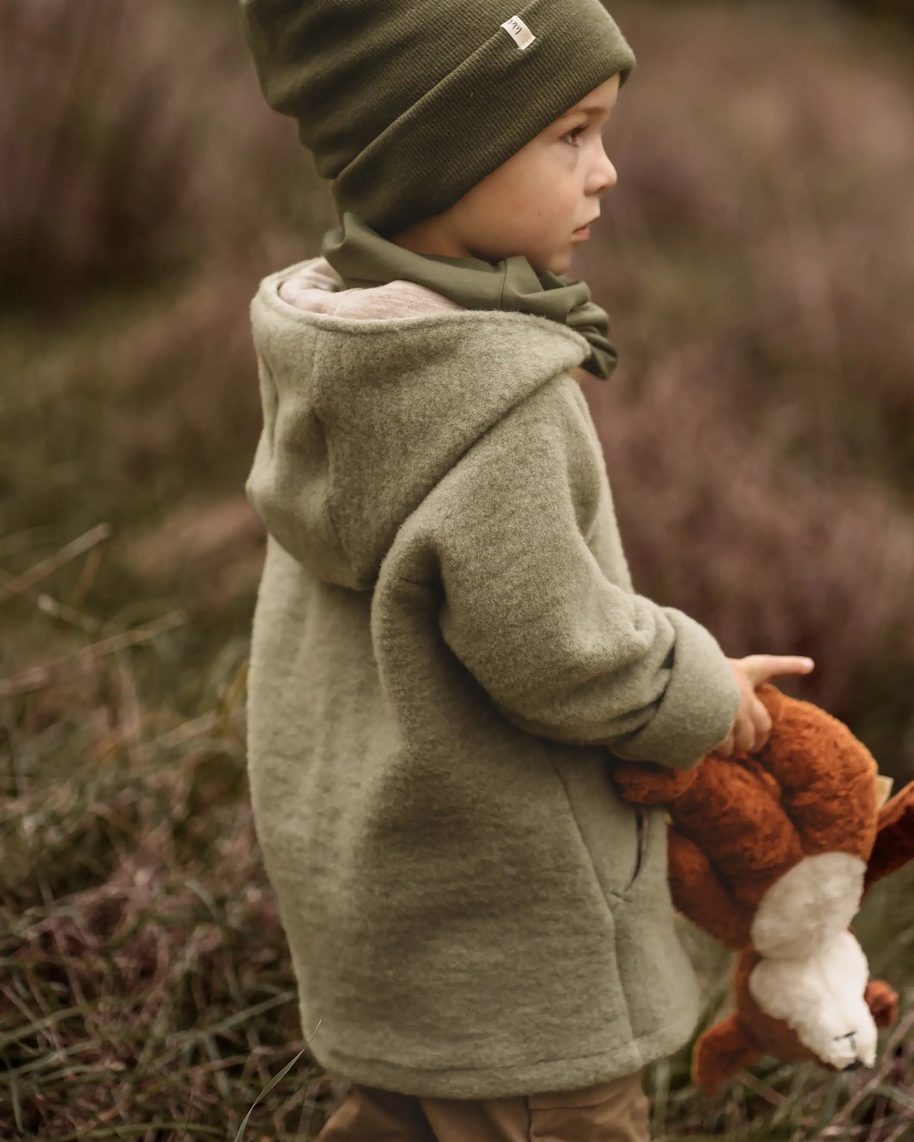 Junge mit Wichtelkidz Merino Wollfleecejacke in Salbei in Wald und Natur mit Merino Beanie