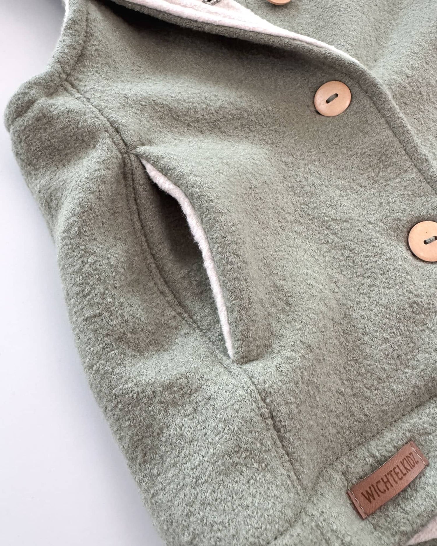 Sofortkauf: Merino-Walkweste mit Holzknöpfen in Salbei/Baumwollfleece Creme, Gr. 98/104