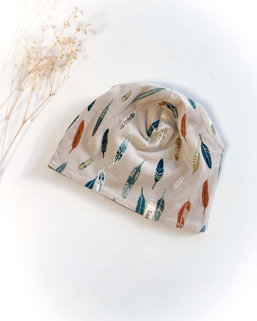 Sofortkauf: Wende-Beanie Schlamm/Federn Gr. 40-42 (ca. 4-5 Monate)