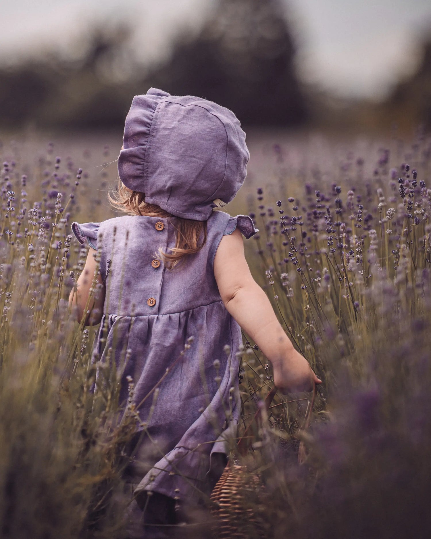 Kinder Stufenkleid / Leinenkleid für den Sommer mit passender Baby Bonnet in Lavendel. Individuell angefertigtes Kleid mit Rüschen, ideal für festliche Anlässe wie eine Taufe, Geburtstag, Hochzeit, als Kleid für ein Blumenmädchen oder die Einschulung.  Unsere Handgemachten Leinenkleider für Mädchen sind nachhaltig, regional und fair in Bayern angefertigt.