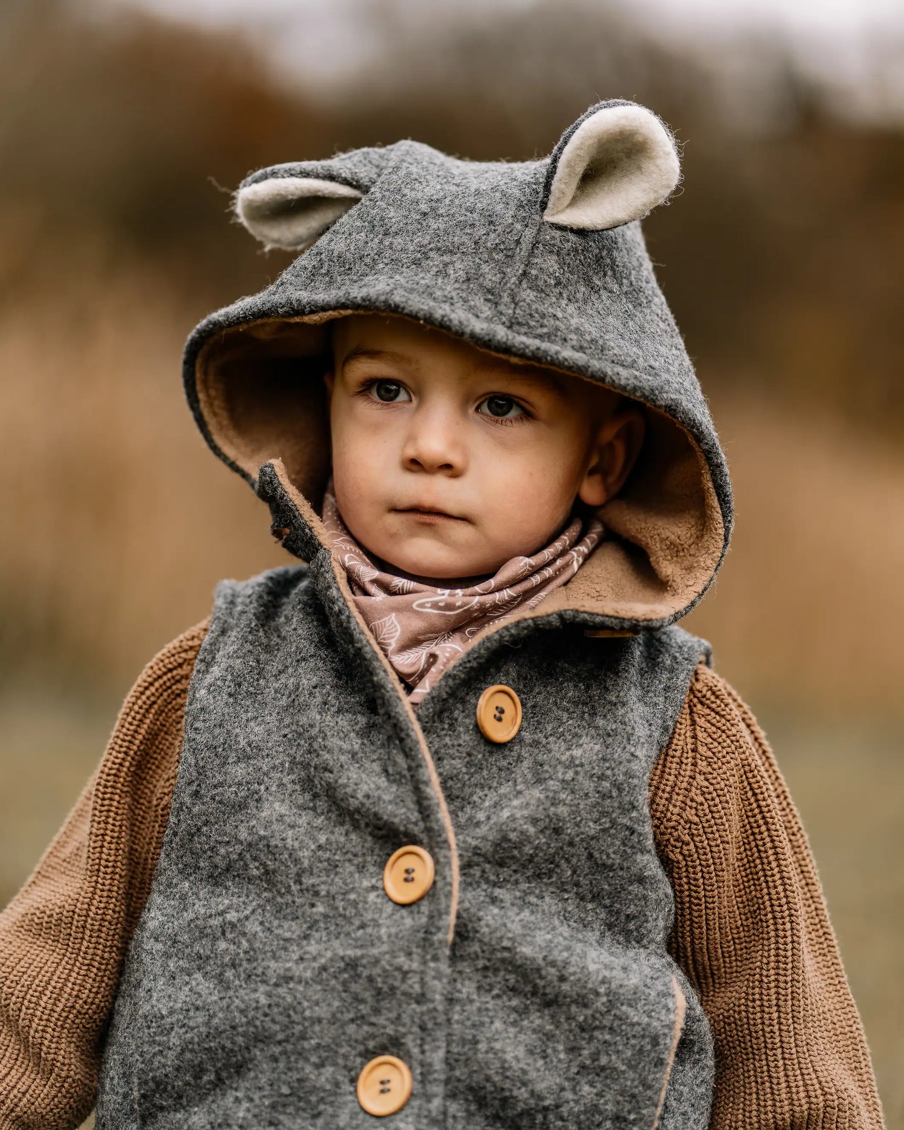 Baby in warmer Walkweste mit Kapuze und Holzknöpfen unterwegs, atmungsaktive und temperaturregulierende Kleidung für Übergangszeit und Winter
